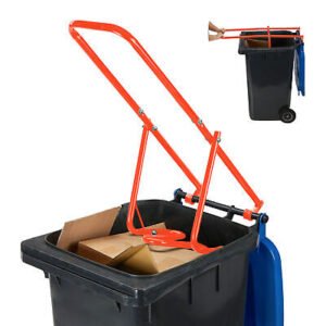 "A red manual household waste compactor attached to a standard wheelie bin. The lever is being pressed down, compacting recyclables and household waste inside the bin. The compact design and durable steel construction make waste compression easy. This image illustrates efficient waste management and space-saving. Please note that decorative items shown are for illustration only and not included in the delivery."